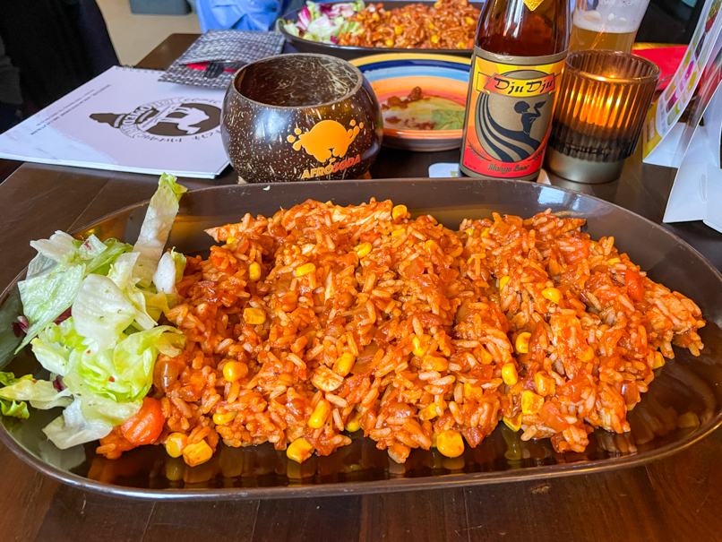 Ein leckeres Hähnchen-Reis Gericht als Hauptspeise im Restaurant Dromedar mit einem Dju Dju Mango Bier. 